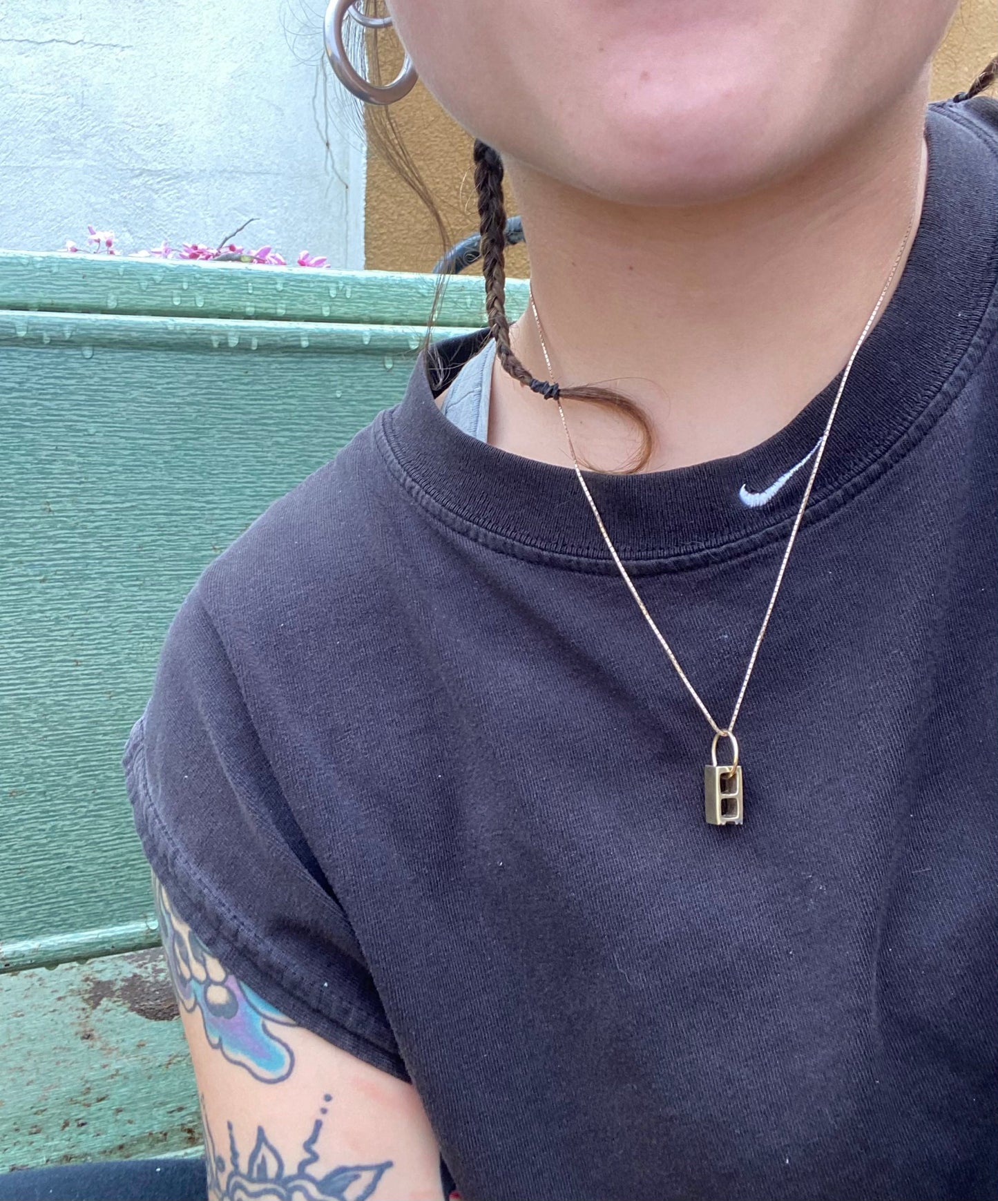 Closeup of someone's neck wearing a mini 10karat yellow gold cinder block on a 1mm yellow gold box chain.